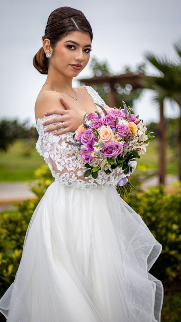 Novia sosteniendo un gran ramo de flores de colores para su boda, representando el servicio de peluquería a domicilio para novias en Barcelona de Magaly Maquillaje.